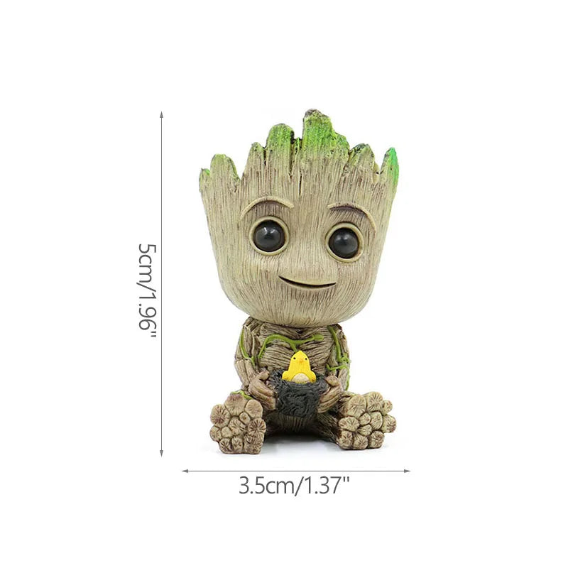 Figura decorativa de personaje árbol pequeño sosteniendo ave amarilla, medidas 5x3.5 cm