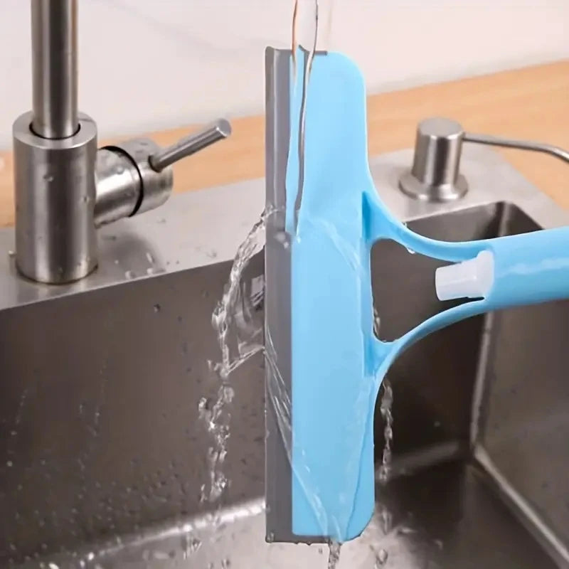 Limpiador azul para ventanas tipo escobilla en fregadero de cocina, agua corriendo