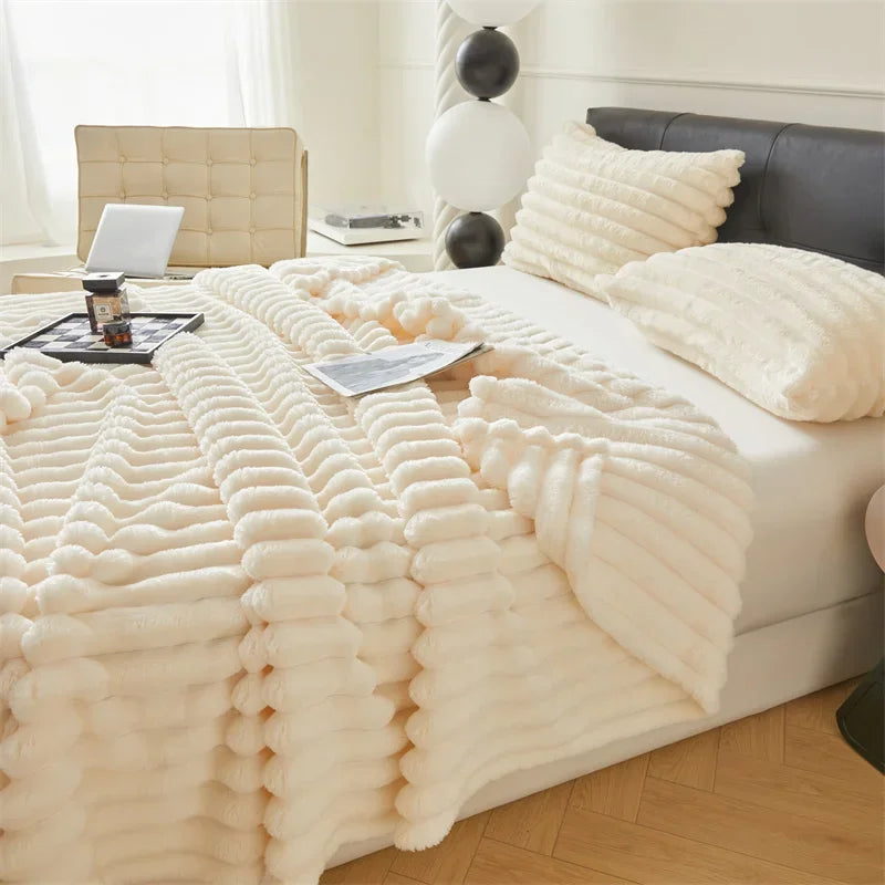 Cama moderna con manta suave de felpa crema y cojines decorativos, dormitorio luminoso.
