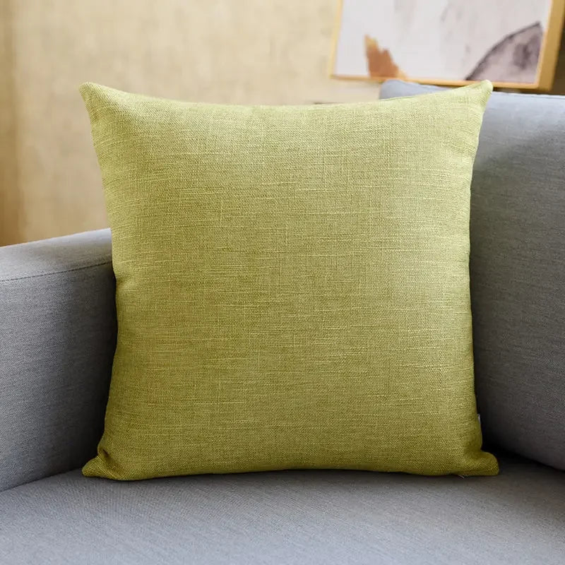 Cojín decorativo cuadrado verde claro sobre sofá gris, accesorio moderno para el hogar