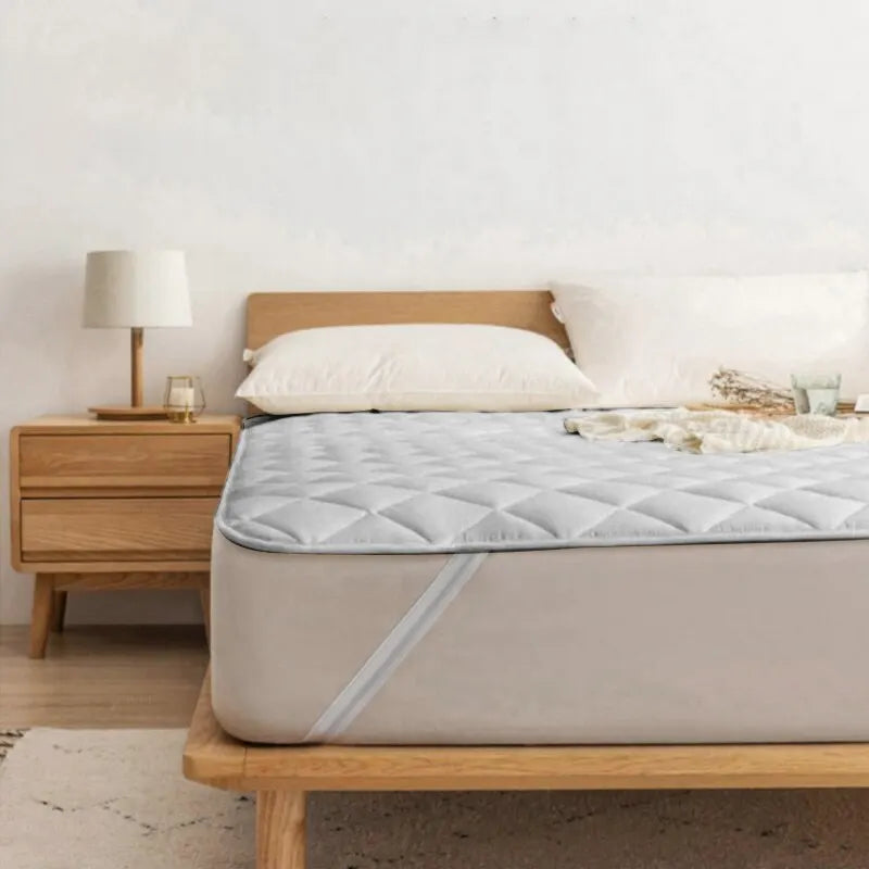 Protector de colchón acolchado gris en cama moderna con cabecera de madera, dormitorio minimalista