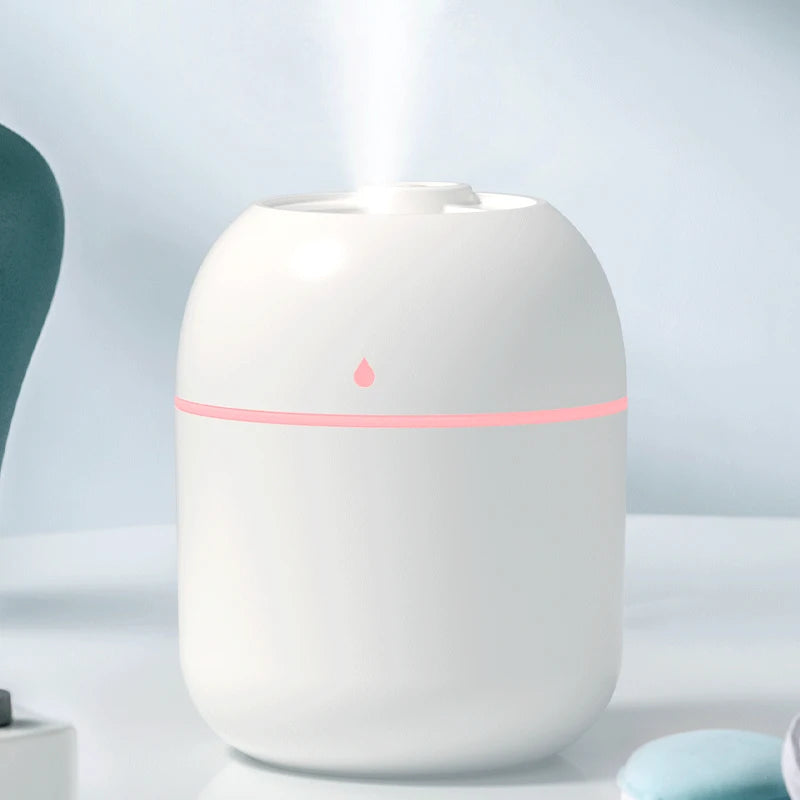 Humidificador blanco moderno con luz LED rosa en ambiente minimalista, ideal para el hogar.