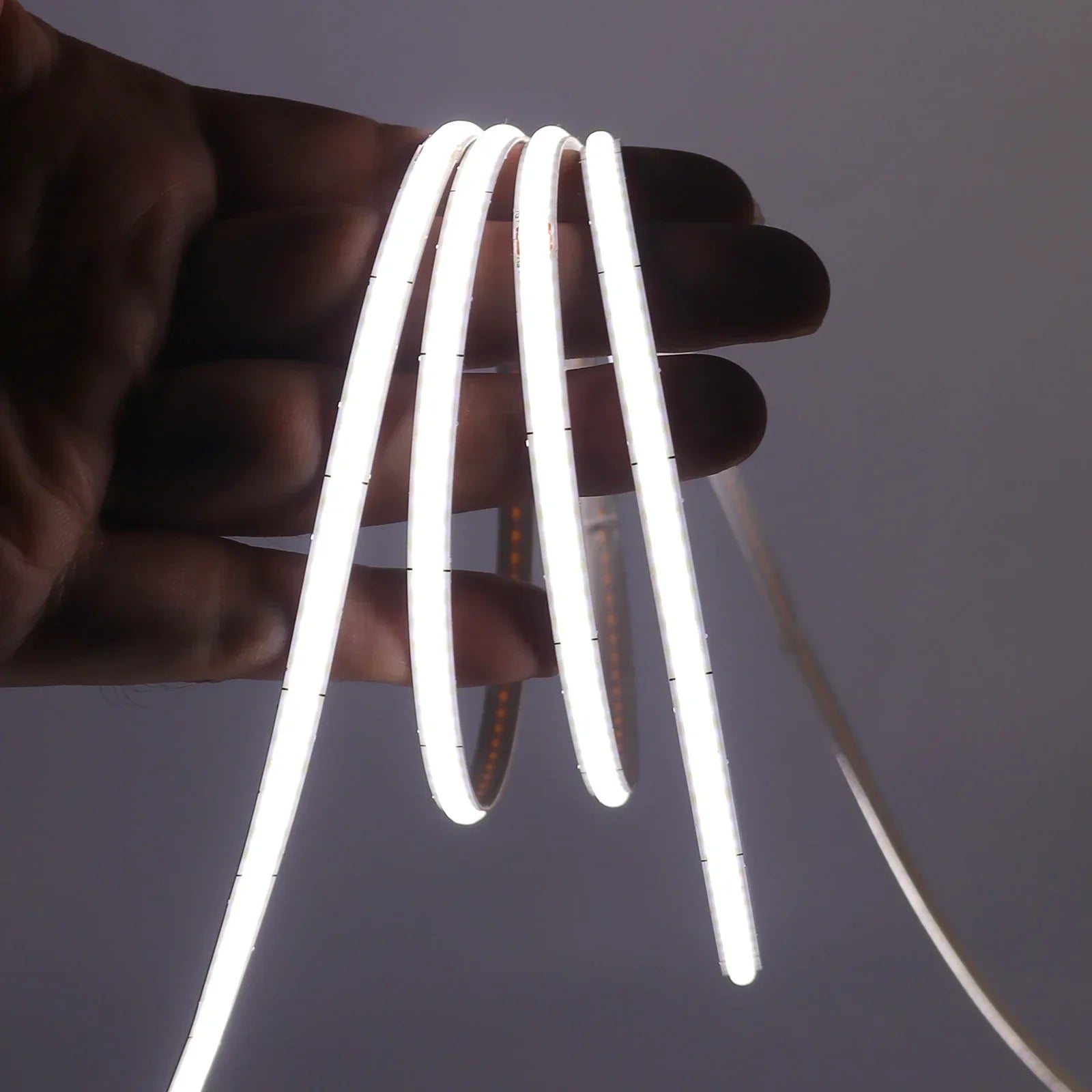 Tira LED flexible de luz blanca sostenida con la mano, ideal para iluminación moderna de interiores