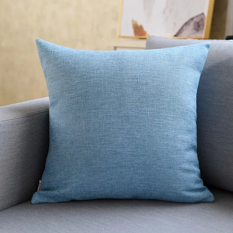 Cojín decorativo azul sobre sofá gris en sala de estar moderna