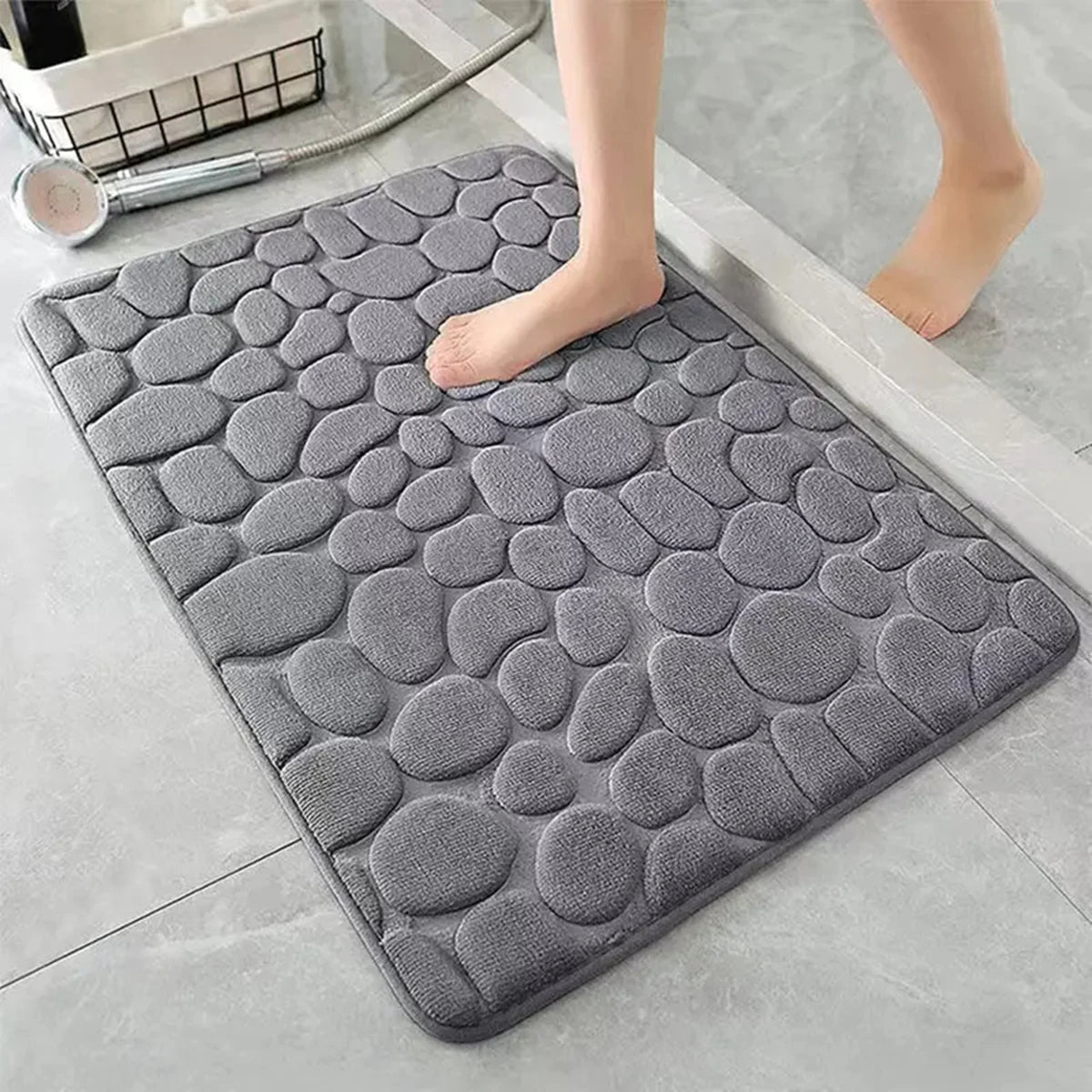 Alfombra de baño antideslizante gris con textura de piedras en suelo moderno, absorbe humedad.